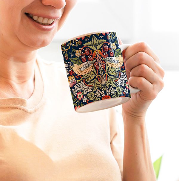 Woman drinking from blue Strawberry Thief coffee mug.